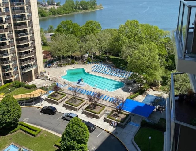 view of swimming pool featuring a water view and a patio