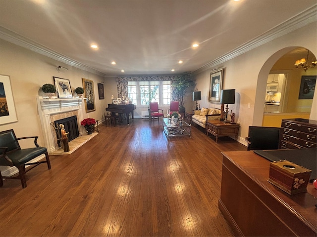 living area featuring arched walkways, crown molding, recessed lighting, wood-type flooring, and a high end fireplace