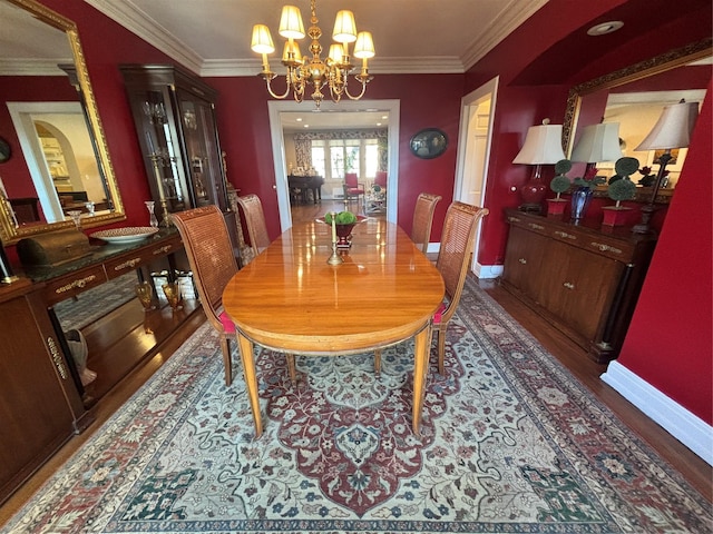 dining area with an inviting chandelier, baseboards, crown molding, and wood finished floors