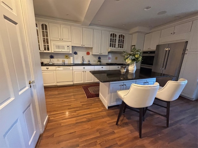 kitchen with dark countertops, white cabinets, stainless steel appliances, and dark wood finished floors