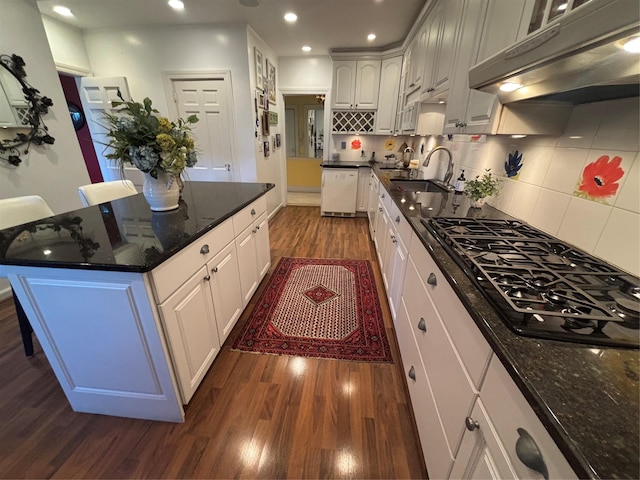 kitchen with black gas stovetop, under cabinet range hood, a sink, dishwasher, and dark wood finished floors