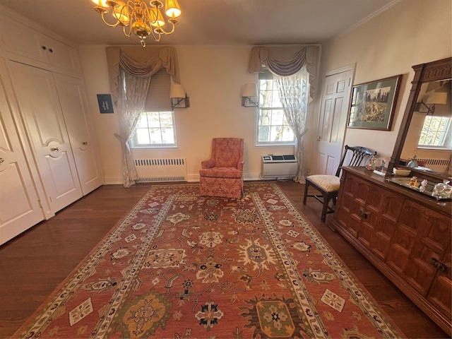 unfurnished room featuring dark wood-type flooring, an inviting chandelier, a wealth of natural light, and radiator