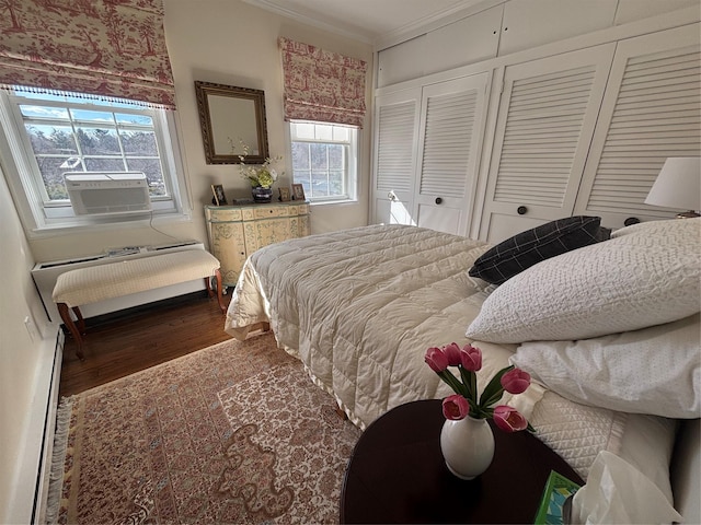 bedroom featuring crown molding, cooling unit, radiator heating unit, and wood finished floors