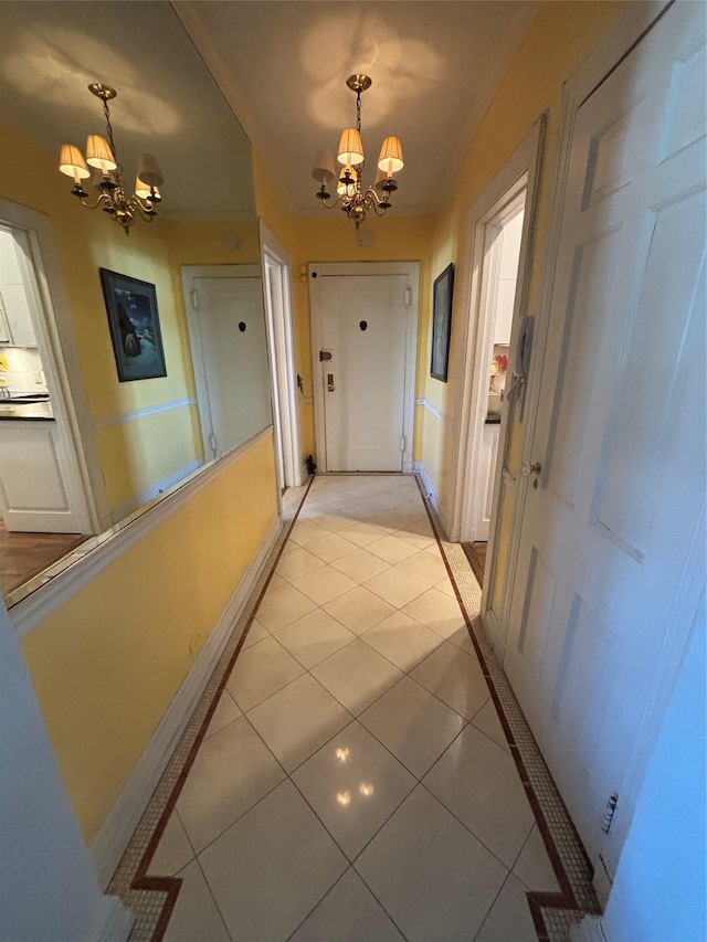 hallway featuring a chandelier, light tile patterned floors, and crown molding