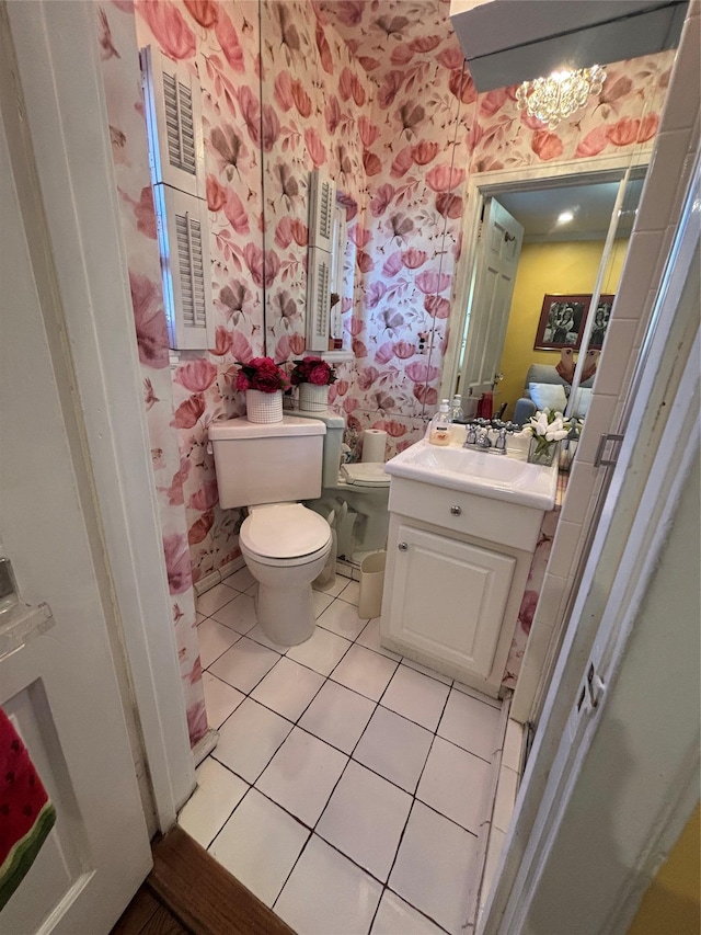 bathroom featuring toilet, wallpapered walls, tile patterned flooring, and vanity