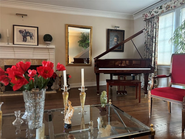 living area featuring baseboards, wood-type flooring, and crown molding