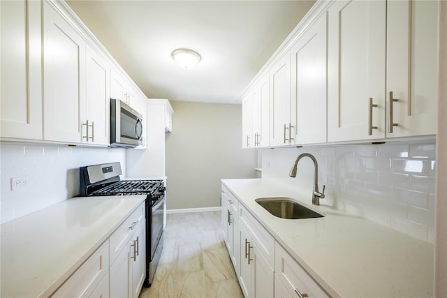 kitchen with stainless steel appliances, white cabinetry, and a sink