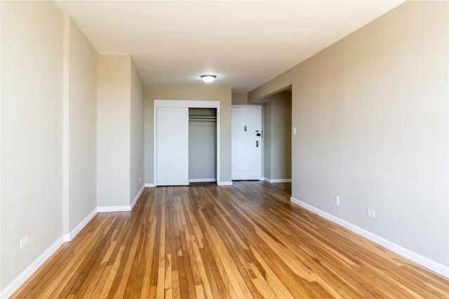 unfurnished room featuring wood-type flooring and baseboards