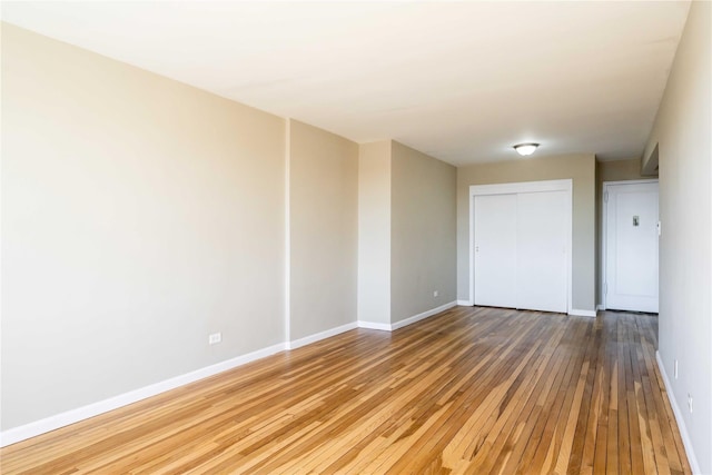 spare room featuring hardwood / wood-style floors and baseboards