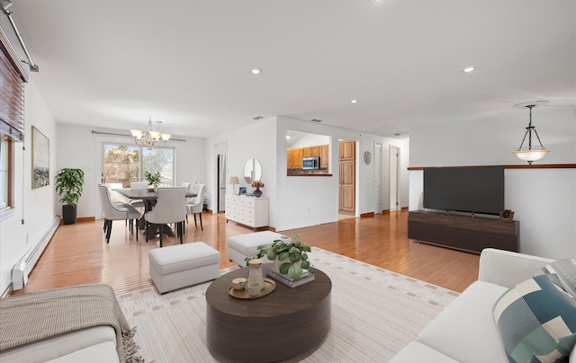 living area with a notable chandelier, recessed lighting, baseboard heating, and light wood finished floors