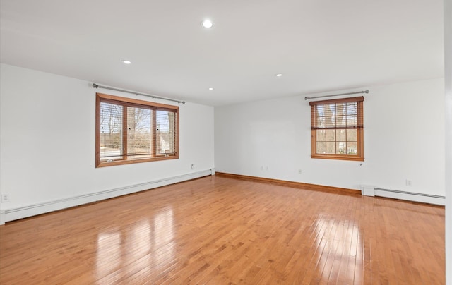 unfurnished room with a baseboard heating unit, recessed lighting, light wood-type flooring, baseboards, and a baseboard radiator