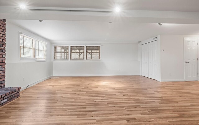 unfurnished living room with light wood finished floors and baseboards