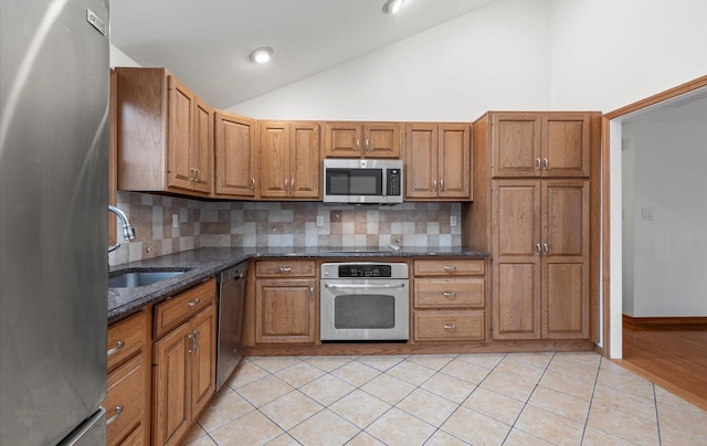 23 Franko Ln, Setauket, NY 11733 - kitchen featuring stainless steel appliances, lofted ceiling, brown cabinets, and decorative backsplash