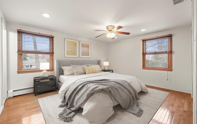 23 Franko Ln, Setauket, NY 11733 - bedroom with a baseboard heating unit, multiple windows, light wood finished floors, and recessed lighting