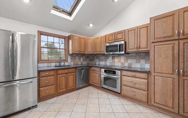 23 Franko Ln, Setauket, NY 11733 - kitchen featuring stainless steel appliances, vaulted ceiling, brown cabinets, decorative backsplash, and a skylight