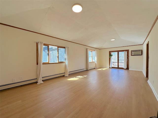 unfurnished room featuring light wood finished floors, a wall mounted AC, ornamental molding, vaulted ceiling, and baseboards