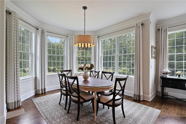 dining space featuring a chandelier, ornamental molding, wood finished floors, and baseboards