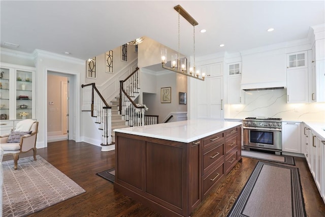 kitchen featuring light countertops, glass insert cabinets, white cabinets, dark brown cabinetry, and high end range