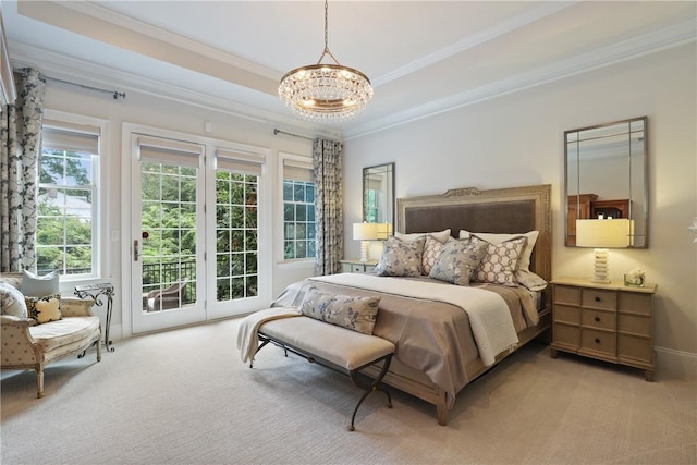 bedroom featuring access to exterior, a tray ceiling, crown molding, light carpet, and a chandelier