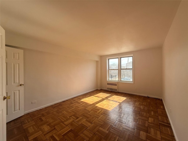 empty room with baseboards and radiator heating unit