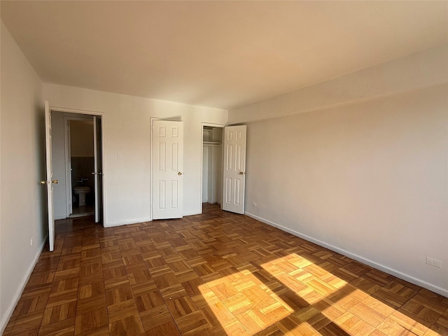 unfurnished bedroom with a closet and baseboards