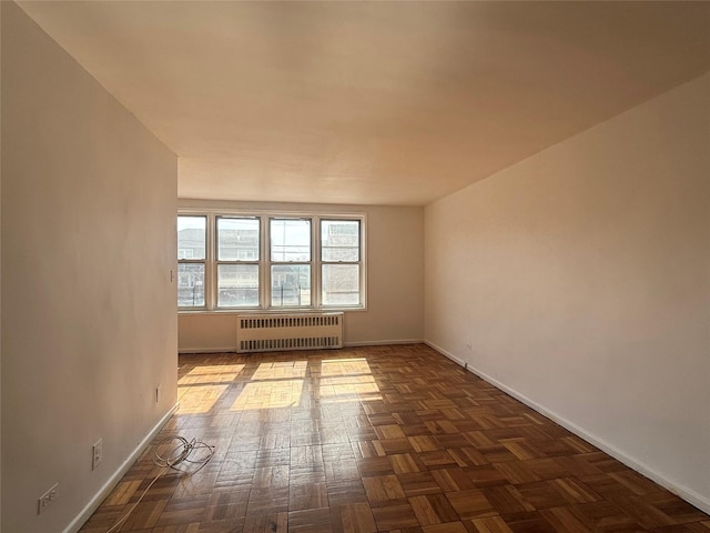 empty room with radiator and baseboards