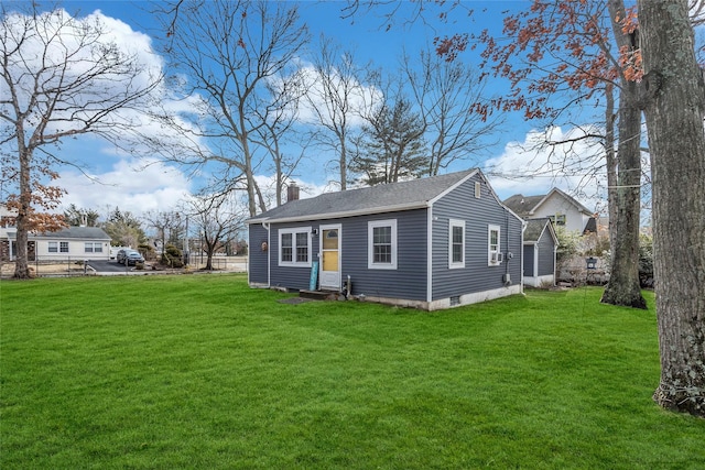 rear view of property featuring a shingled roof, entry steps, a lawn, and a chimney