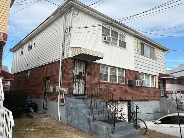 view of front of home featuring cooling unit and brick siding