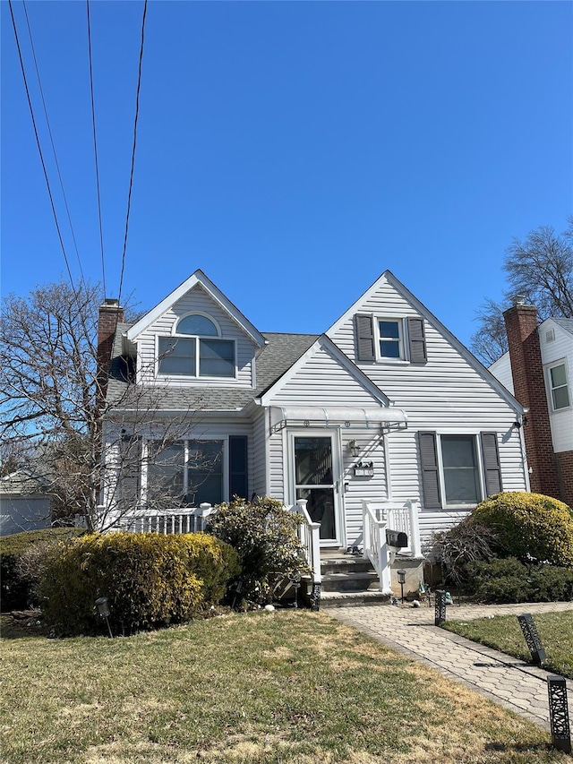 view of front of property with a chimney and a front lawn