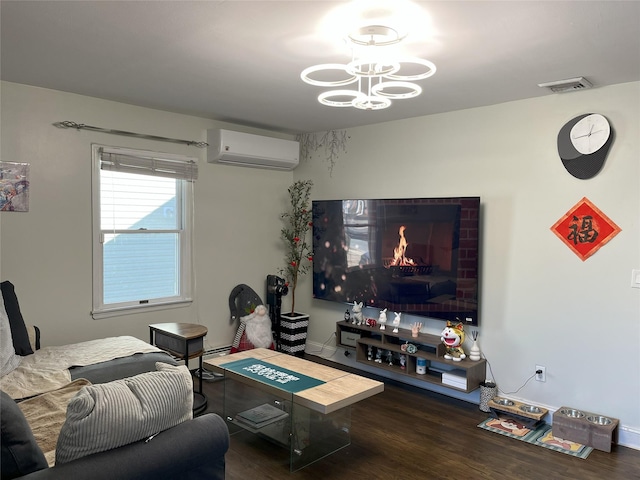 living room with visible vents, wood finished floors, a brick fireplace, a chandelier, and a wall mounted AC