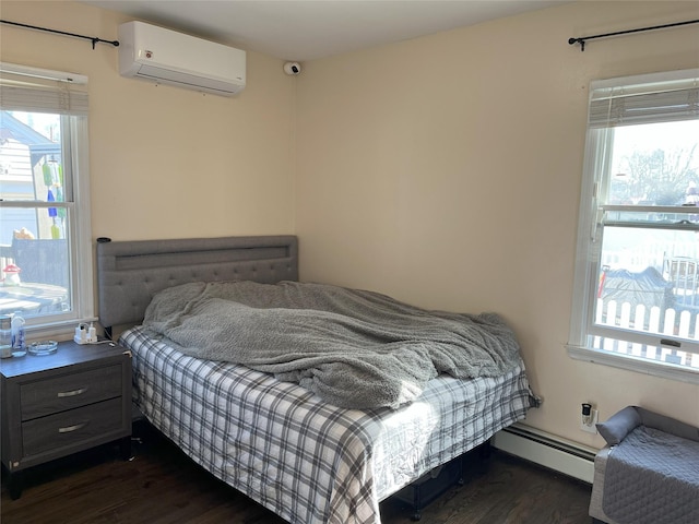 bedroom featuring a baseboard heating unit, a wall mounted air conditioner, and dark wood-type flooring