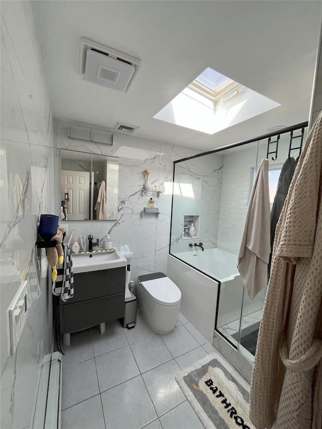 bathroom featuring toilet, a skylight, visible vents, vanity, and tile walls