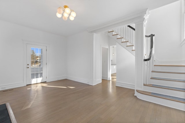 interior space featuring baseboards, stairway, and wood finished floors