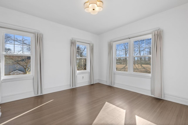 unfurnished dining area with baseboards and wood finished floors