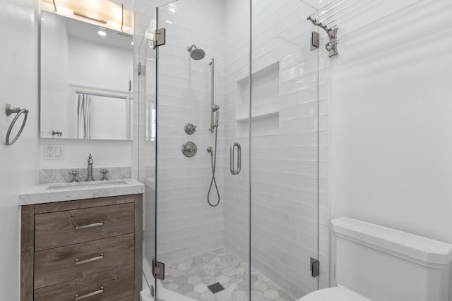 full bath with a stall shower, vanity, and toilet