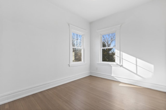 spare room featuring wood finished floors and baseboards