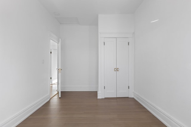 unfurnished bedroom with a closet, baseboards, and wood finished floors