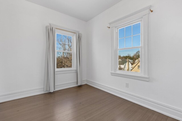 empty room featuring dark wood-style flooring and baseboards