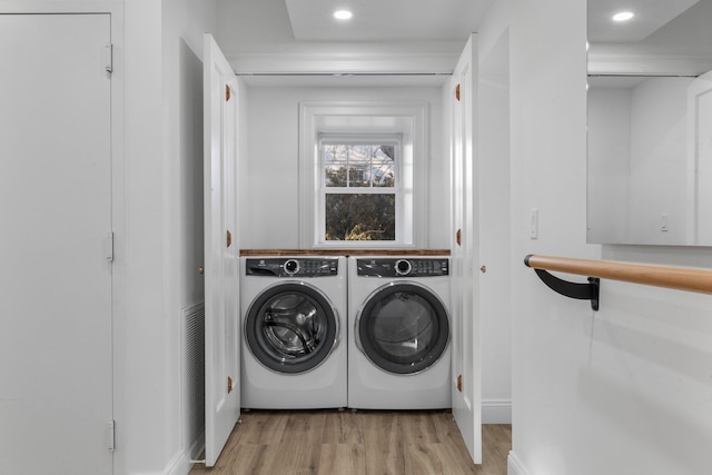 laundry room with laundry area, washer and clothes dryer, light wood-style floors, and recessed lighting