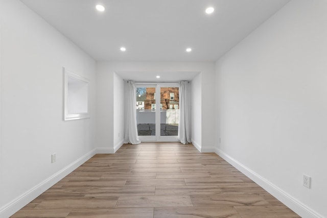 unfurnished room with light wood finished floors, recessed lighting, and baseboards