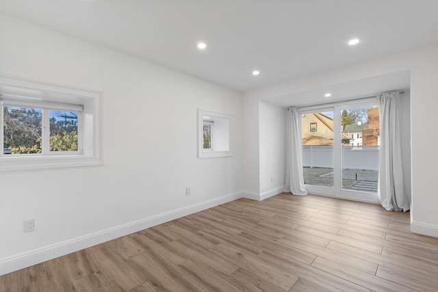 spare room featuring light wood finished floors, baseboards, and recessed lighting