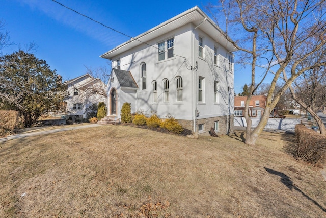 view of front of property featuring a front lawn and stucco siding