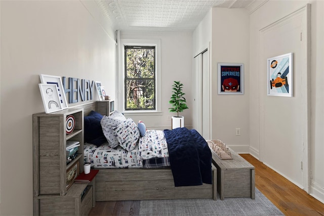 bedroom with baseboards and wood finished floors