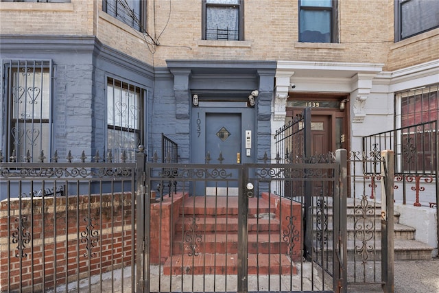 doorway to property with stone siding and fence