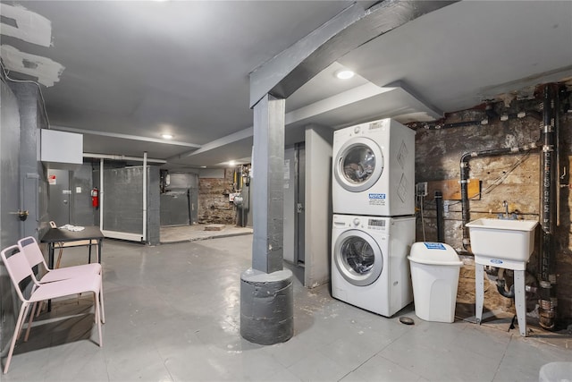 unfinished below grade area with a sink and stacked washer / drying machine