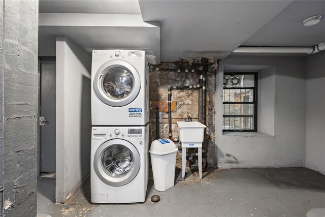 laundry room with stacked washer / dryer, laundry area, and a sink