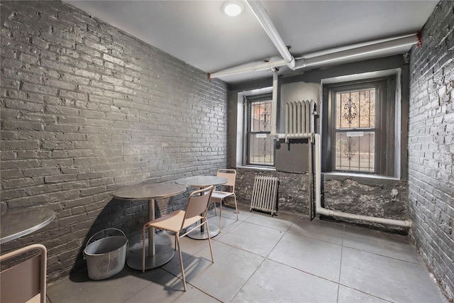 interior space with brick wall and tile patterned floors