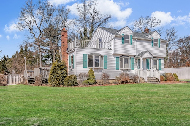 view of front of property with a chimney, a front yard, and fence