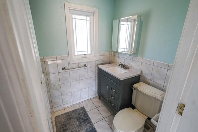 bathroom with vanity, tile patterned flooring, toilet, and tile walls