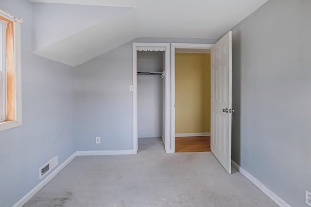 unfurnished bedroom with visible vents, a closet, baseboards, and carpet flooring